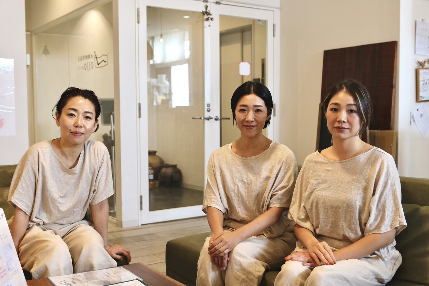 ソファーに並んで座るスタッフ3人