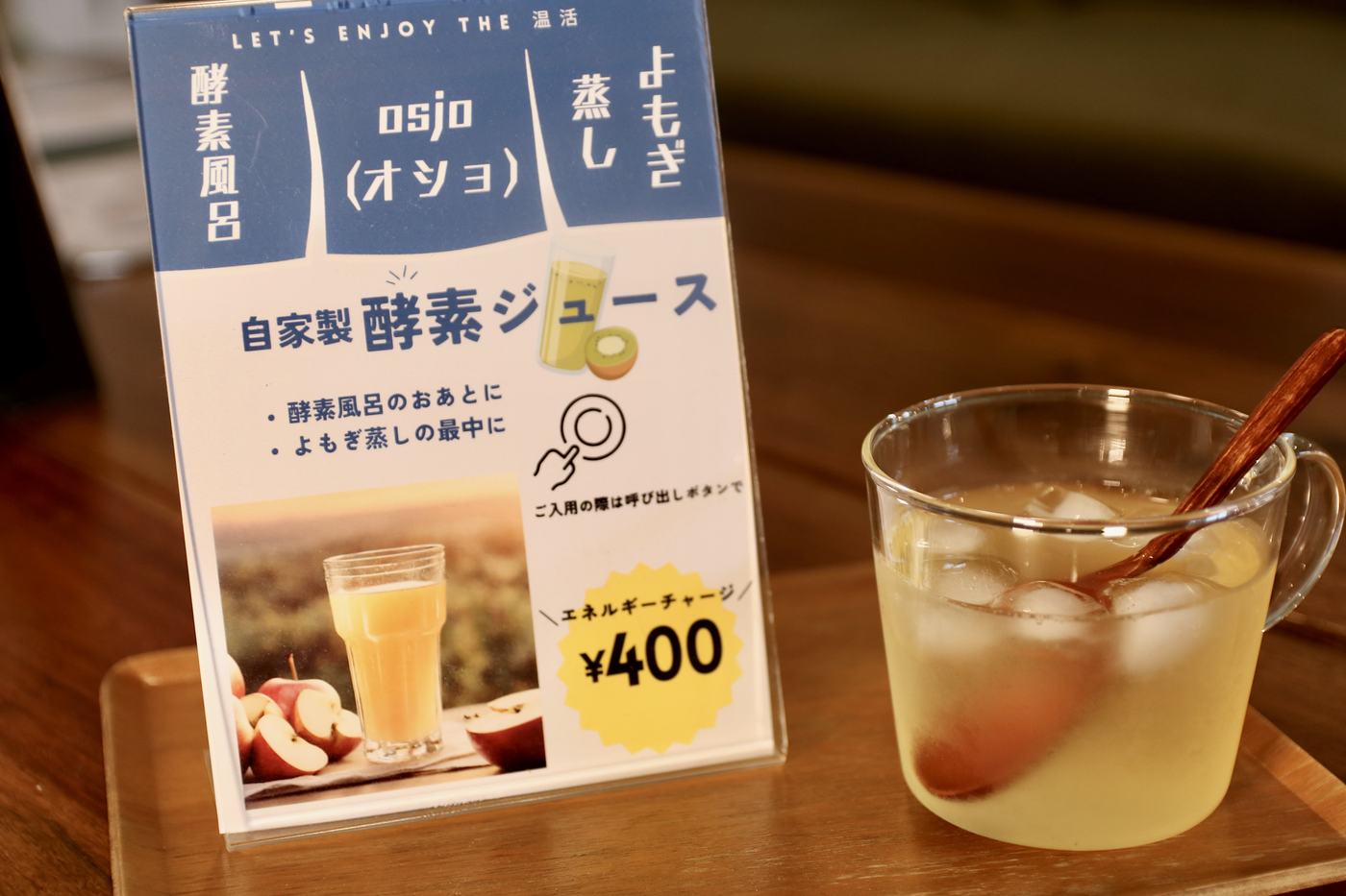「自家製酵素ジュース ¥400」の案内札と、氷の入ったジュースのカップ