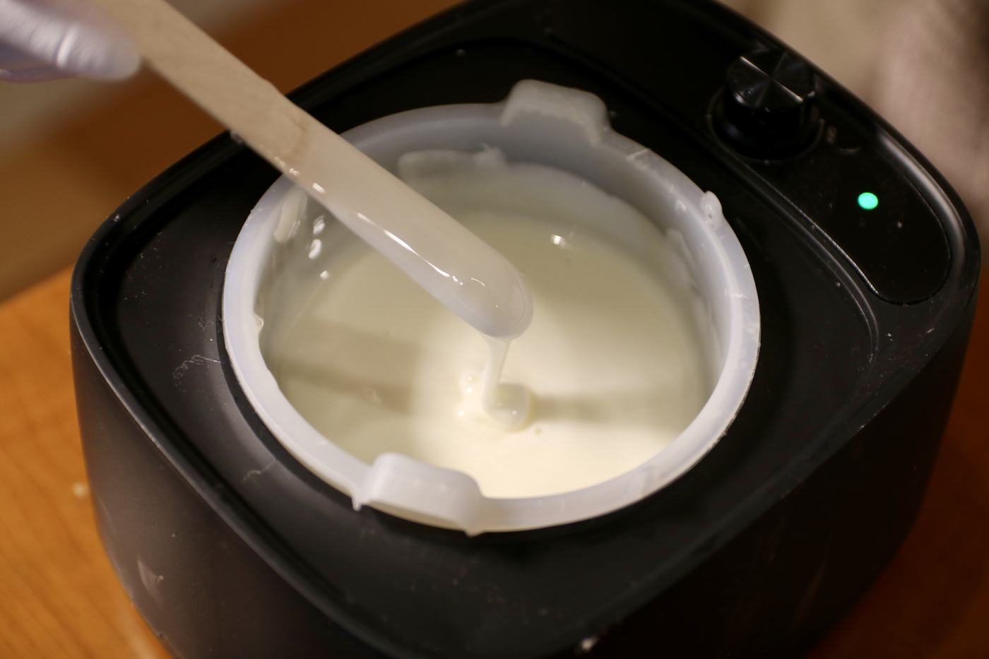 容器の中の白いパック剤を、ヘラですくう